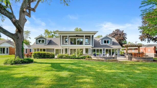 A large, two-story house with a covered patio and a well-maintained lawn. - Spacious 5-Bedroom Golf Course Home for Getaways (Merrillville)