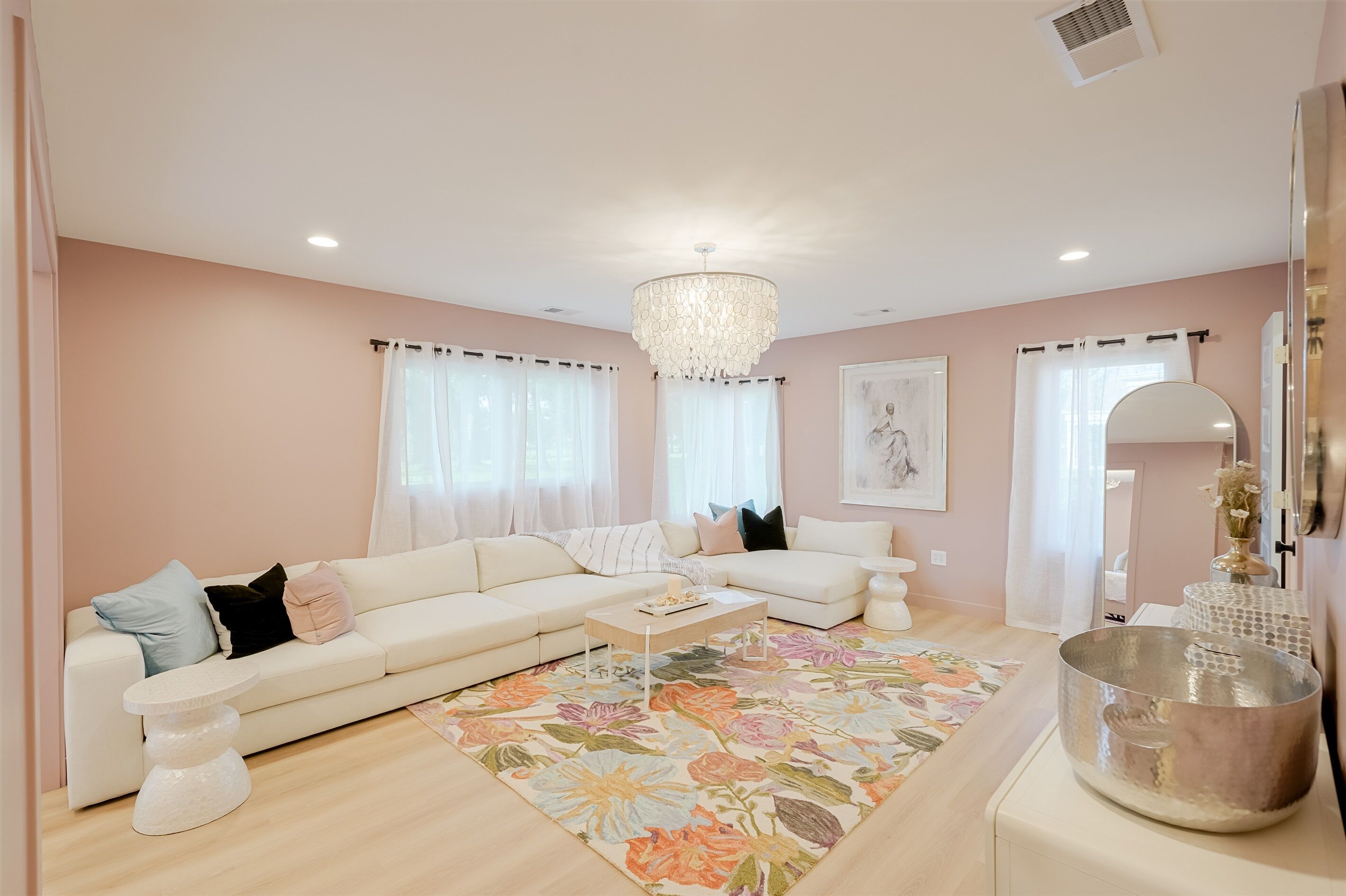 Una sala de estar con un sofá color beige, una mesa de centro, un candelabro y un tapete floral.