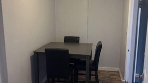 A small, narrow room with a ceiling fan, a table with chairs, and a door. - Cozy & comfortable Guest house Near Hard Rock Stadium (Miami)