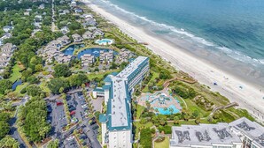 An aerial view of a coastal hotel with multiple swimming pools, a beach, and a parking area. - Welcome to Coastal Calm at Bridgewater 
Oceanfront at LBTS at Pawleys Island (Pawleys Island)