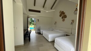 A hotel room with two beds, a desk, and a view of a pool. - Yeguas V18 by Wynwood House (Anapoima)