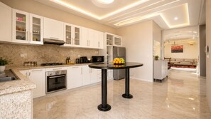 A modern kitchen with white cabinets, a black countertop, and a round table with fruit. - Villa with private pool - total calm near Agadir (Agadir)