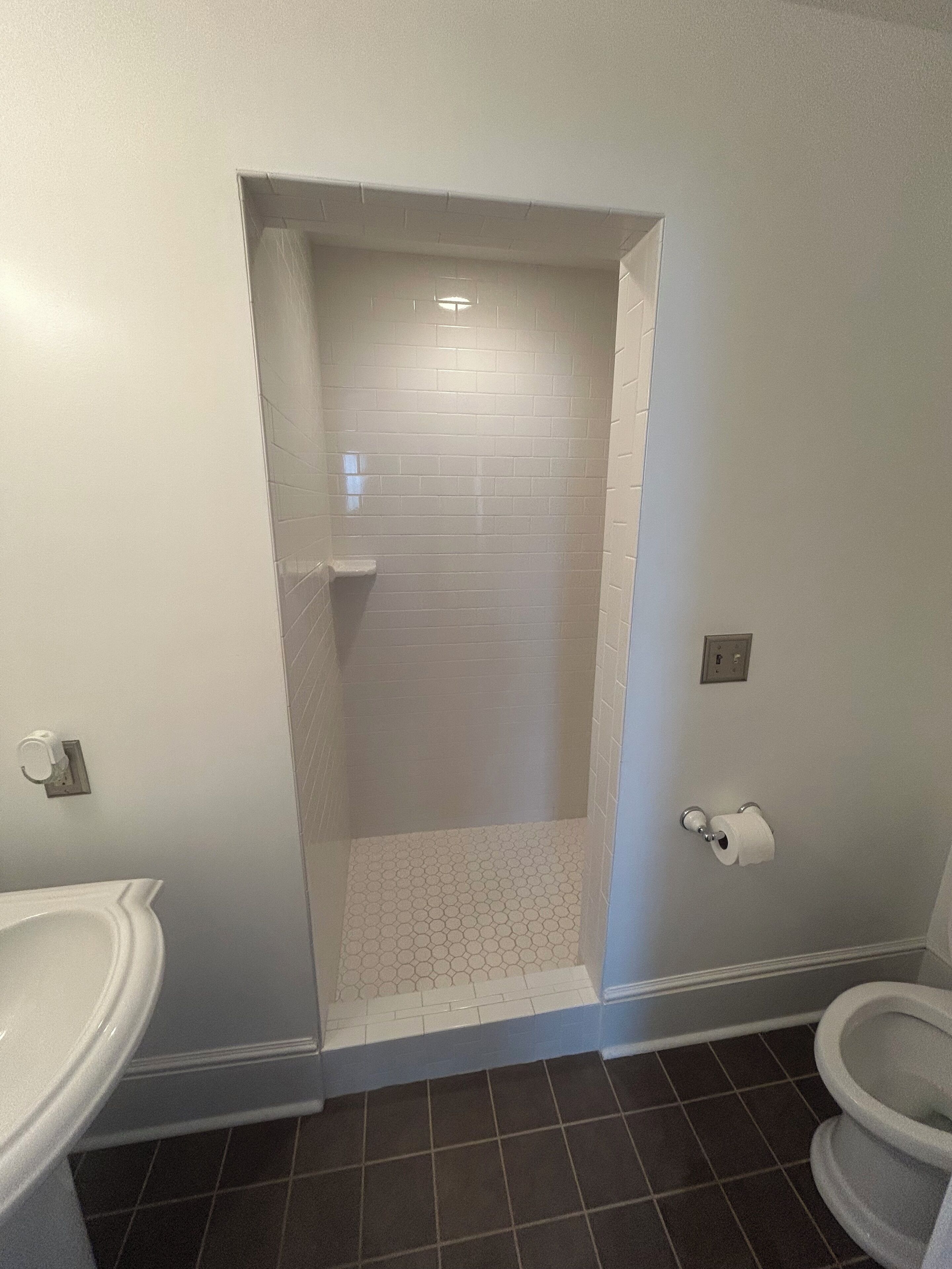 A bathroom with a shower, toilet, and sink.