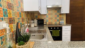 A kitchen with colorful tiles, a sink, a stove, and cabinets. - Year-Round Sun! COZY 1BR Studio,Long Stays,Remote Workers,Parking, Paphos center (Paphos)