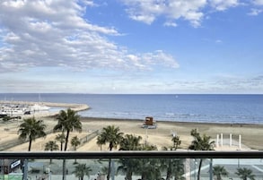 Vista de una playa con palmeras, un muelle y un pequeño edificio sobre la arena.