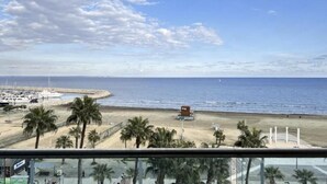 A beach view with palm trees, a pier, and a small building on the sand. - Stayspro - Venice Beach Luxury Apartments (Marina del Rey)
