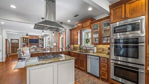Une cuisine moderne avec des meubles en bois, des appareils électroménagers en acier inoxydable et un îlot central.