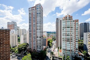 A high-rise building with multiple floors, surrounded by other buildings and greenery. - JAUAPERI 207 (Indianópolis São Paulo)