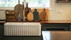 A kitchen with a white sink, wooden cutting boards, and a dish rack. - Country Living on 1 acre in Paso Robles w/ AC, BBQ, starry nights, Dogs welcome (Paso Robles)