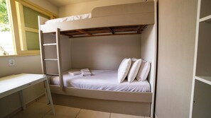 A bunk bed with a desk and a window.