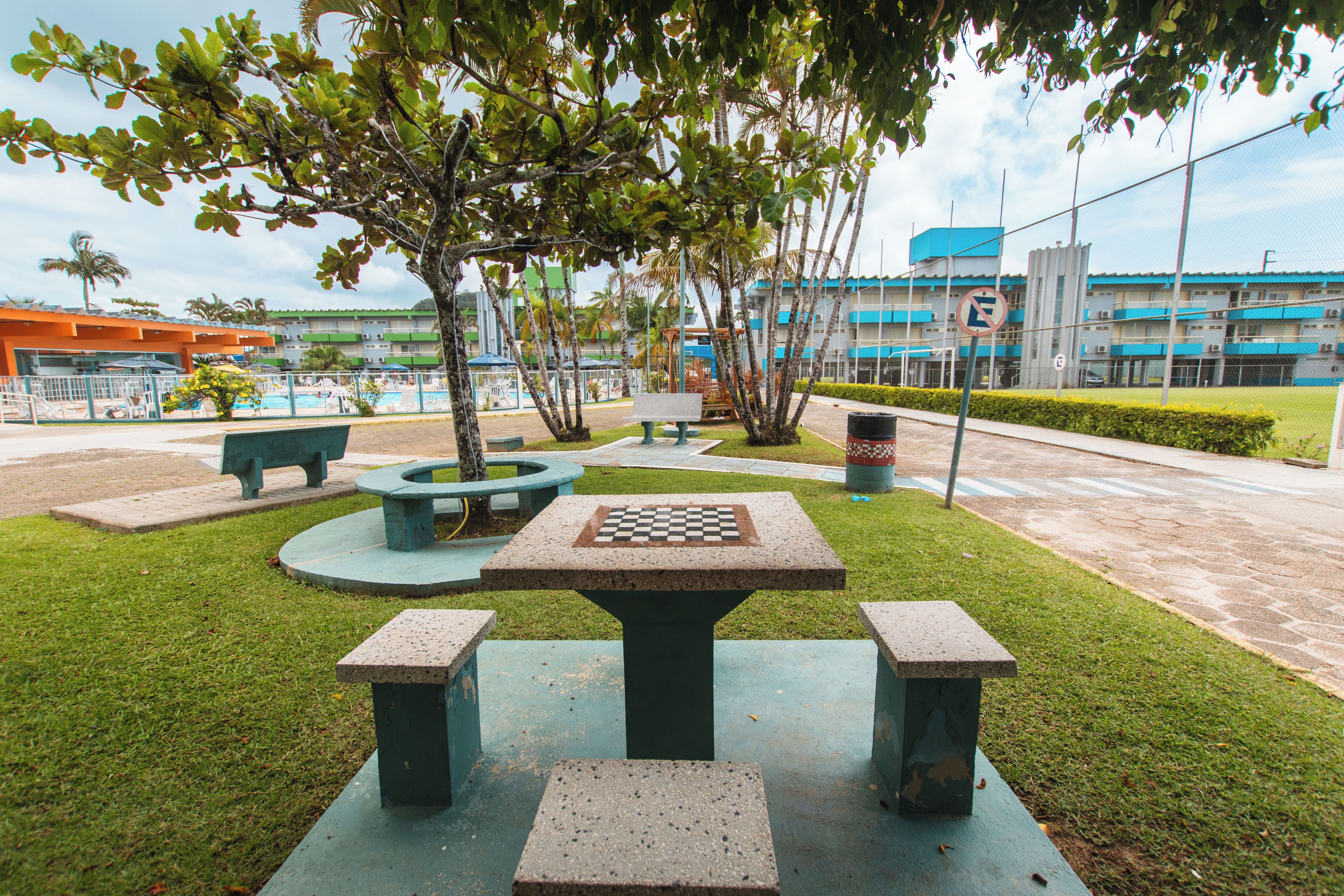 An outdoor area with a chess table, benches, and a pool.