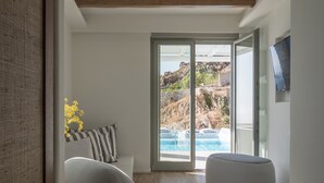 Un salon moderne avec vue sur une piscine et des montagnes.