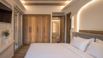 Quarto moderno com uma cama grande, guarda-roupa de madeira e um vaso com planta.