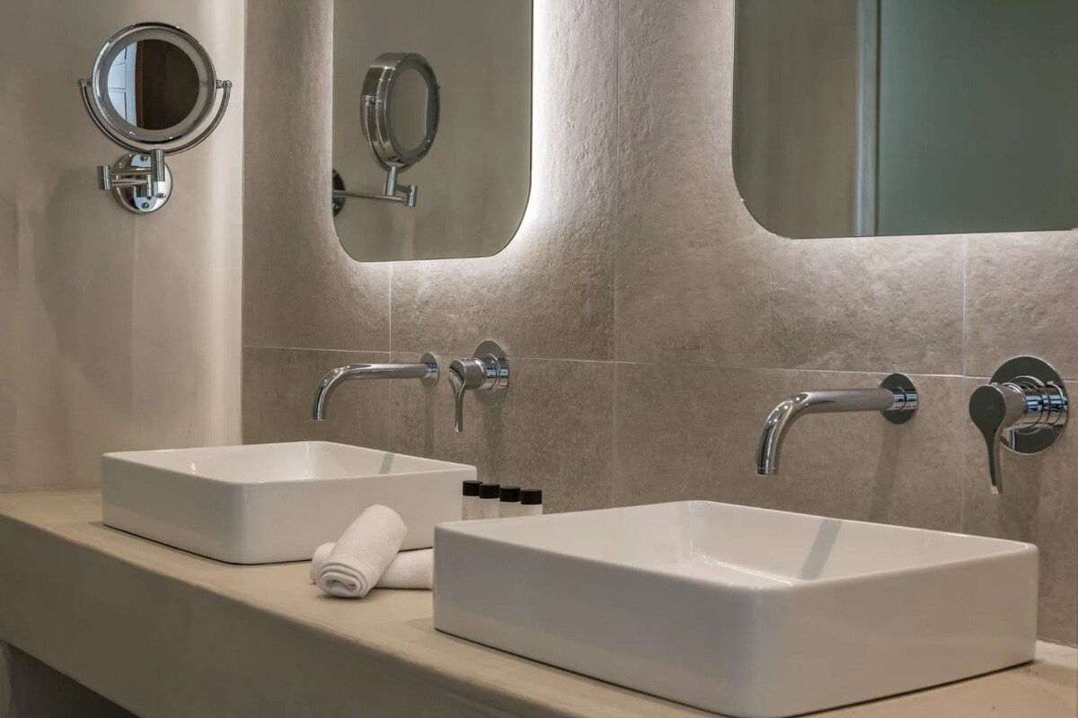 A bathroom with two white sinks, a towel, and a mirror.