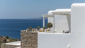 Un bâtiment blanc avec un mur en pierre et une vue sur la mer.