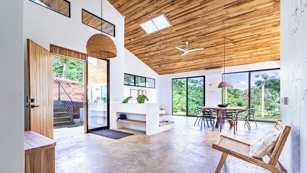 A spacious living area with a wooden ceiling, large windows, and a modern dining setup. - Private Eco-Luxury Villa near Rio Celeste | Jacuzzi • Nature • Sleeps 8 • (El Higueron de Upala)