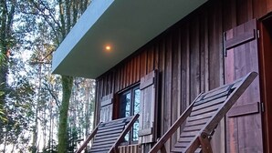 Una cabana moderna de fusta amb teulada inclinada i una finestra gran.