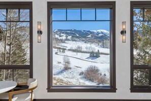 A room with a large window offering a view of a snowy landscape with mountains. - Vista Haus at Country Club - golf and ski retreat! (Mountain Village)