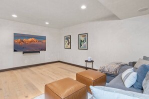 A modern living room with a flat-screen TV, two framed pictures, a sofa with cushions, and a wooden floor. - Vista Haus at Country Club - golf and ski retreat! (Mountain Village)