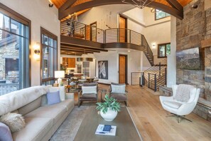 Amplia sala de estar con chimenea, comedor y cocina. Una escalera conecta los dos pisos.