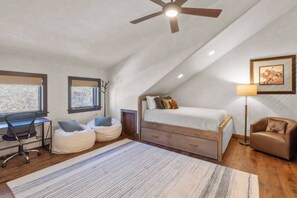 A bedroom with a sloped ceiling, a bed, a desk, two bean bags, a chair, a floor lamp, and a framed picture on the wall. - Vista Haus at Country Club - golf and ski retreat! (Mountain Village)