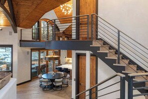 A multi-level interior with a staircase, a dining area, and a view through a glass door. - Vista Haus at Country Club - golf and ski retreat! (Mountain Village)