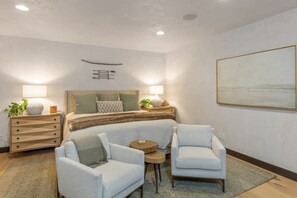A bedroom with a large bed, two armchairs, a nightstand, and a painting on the wall. - Vista Haus at Country Club - golf and ski retreat! (Mountain Village)