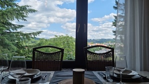 Une table dressée pour deux personnes, avec vue sur la ville et la verdure.
