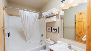 Un baño con bañera, inodoro, lavabo y cortina de ducha.