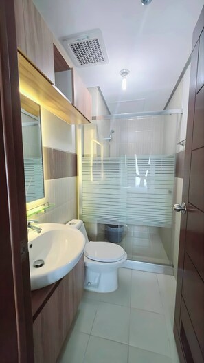 A modern bathroom with a sink, toilet, and shower. - Amisa Private Residences Tower C (Lapu-Lapu)