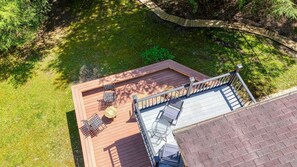 Una terraza con mobiliario exterior, una mesa de vidrio y una barandilla de metal.