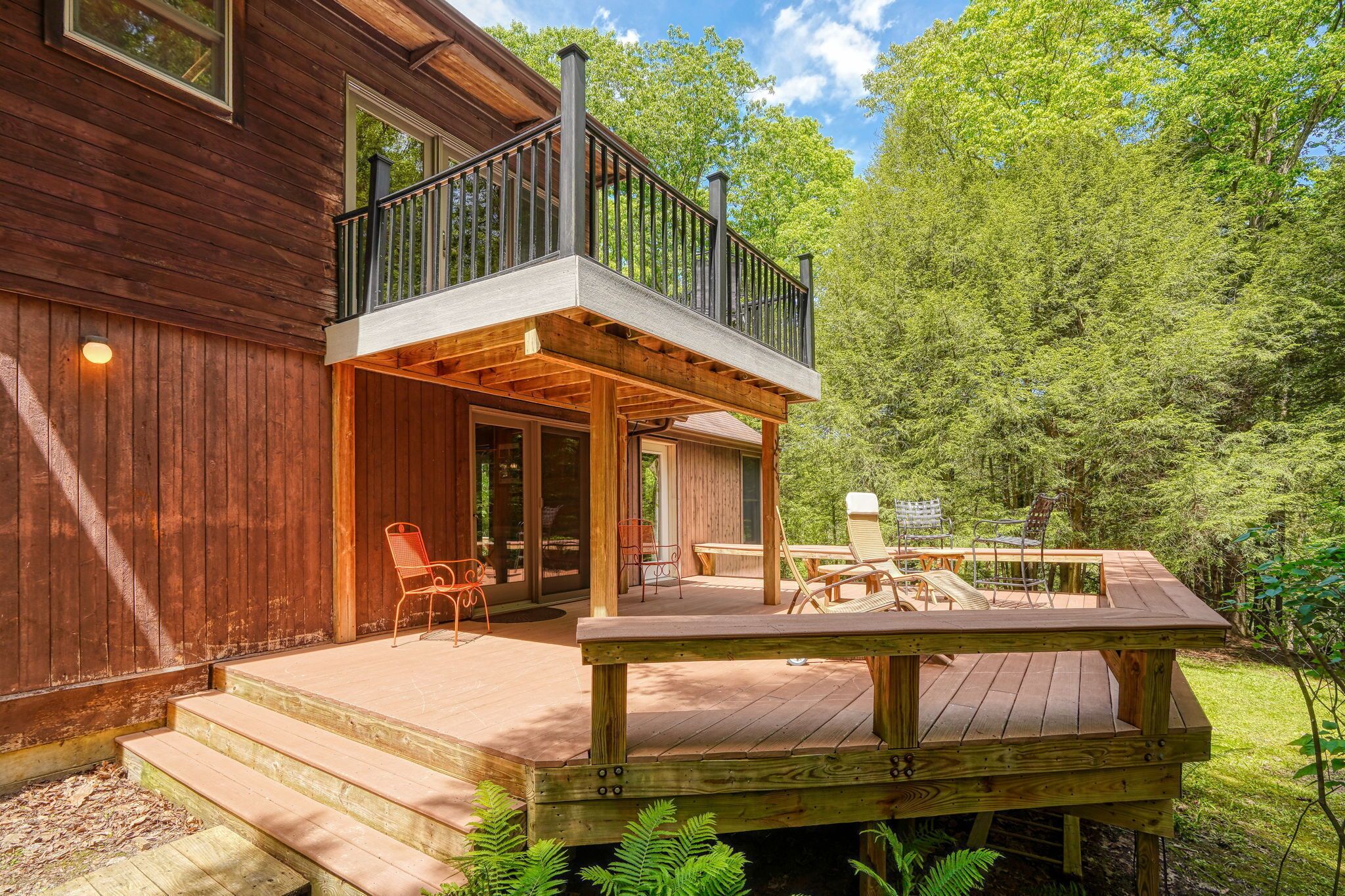 A wooden deck with outdoor furniture and a balcony.