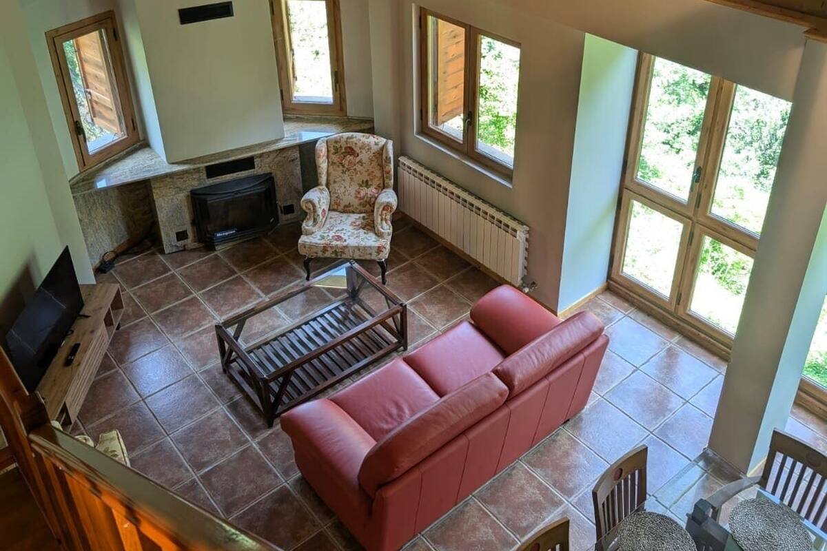 A spacious living area with a fireplace, a sofa, and a dining table with chairs.