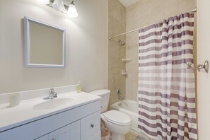 A bathroom with a white sink, a mirror, a toilet, and a shower curtain. - 5 Mi to Jupiter Beach Park: Poolside Oasis! (Jupiter)