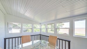 A room with a glass table surrounded by chairs, large windows, and a white ceiling. - Waterfront Lake Eufaula Home: Dock & Beach Access! (Eufaula)
