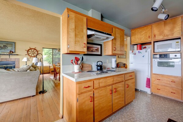 Una cocina con armarios de madera, encimera blanca y refrigerador blanco.
