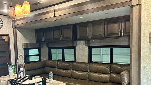 A modern RV kitchen with a built-in seating area, a ceiling fan, and pendant lights. - Cozy 2-bedroom mobile home in front of lake pleasant. (Beaver)