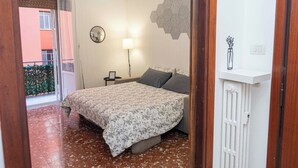 A bedroom with a bed, a bedside lamp, a mirror, and a radiator. - The little house in the hills - Appio/Tuscolano (Roma)