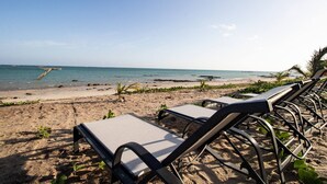 Una spiaggia con lettini e una vista libera sull'oceano.