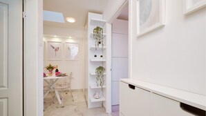 A modern kitchen with white cabinetry, a marble countertop, and a dining area with a glass table and chairs. - Awesome apartment in Mali Losinj with WiFi (Mali Losinj)