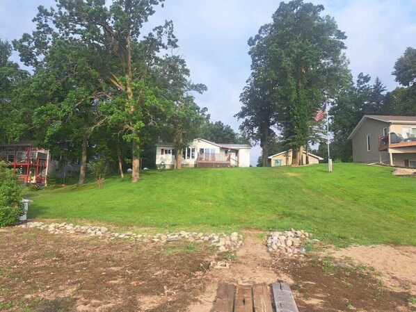 A residential area with houses, a lawn, and trees.
