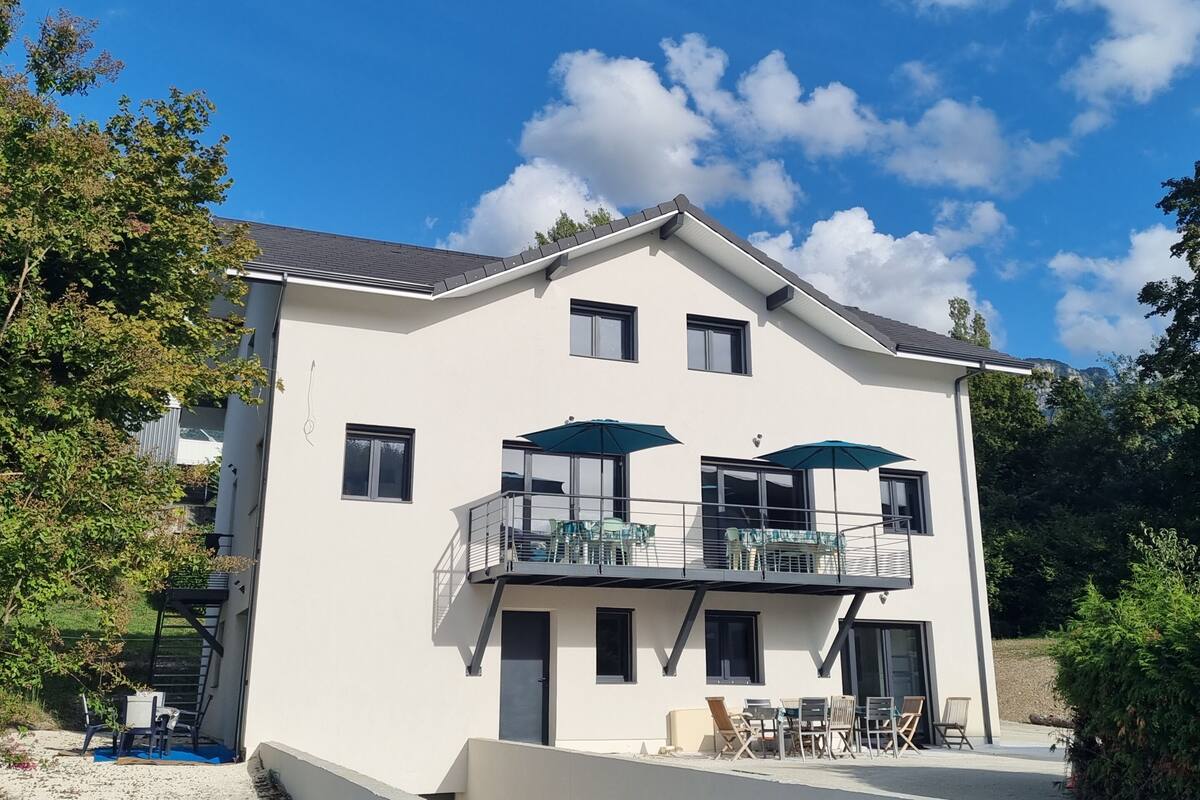 Ein zweistöckiges Gebäude mit Balkon, Außenbereich und blauem Himmel.