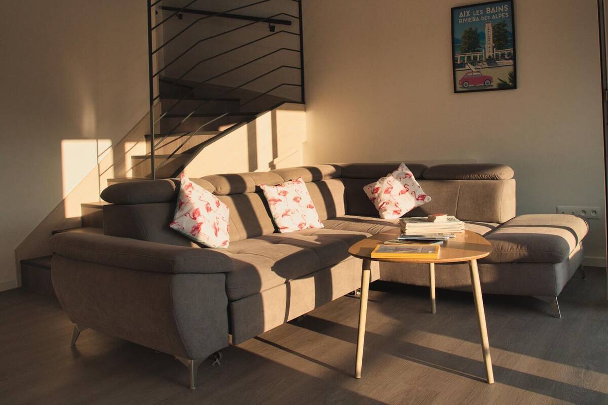 Ein modernes Wohnzimmer mit einer Couch, einem Couchtisch und einer Treppe.