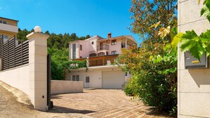 A residential building with a paved driveway, a gated entrance, and a balcony with a railing. - Stunning home in Trogir (Trogir)