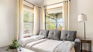 A bedroom with a bed, a bedside table with a plant, and a lamp. - Bluejay Bungalow – Cozy Pet-Friendly Cottage Near Yosemite & Bass Lake (Oakhurst)