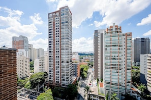 A high-rise building with multiple floors, surrounded by other buildings and greenery.