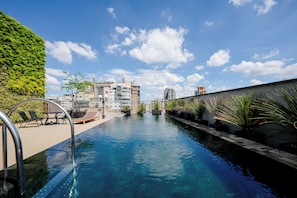 Ein Schwimmbecken mit Blick auf Gebäude und einem klaren Himmel.