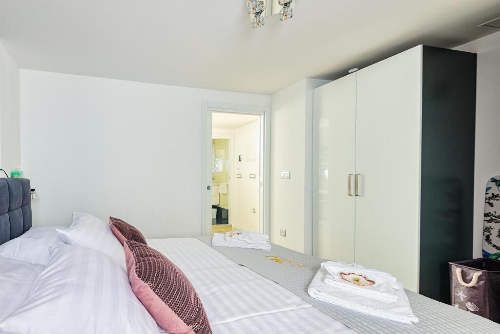 Une chambre d’hôtel comprenant un lit, une armoire, un miroir et une porte donnant sur une autre pièce.