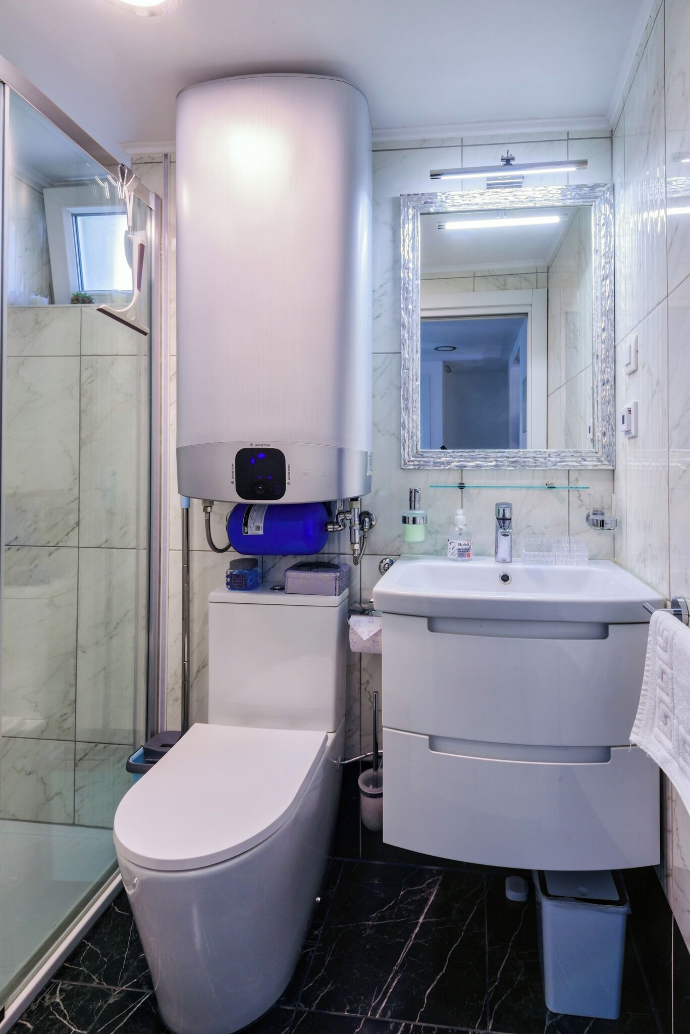 A modern bathroom with a toilet, sink, and shower.