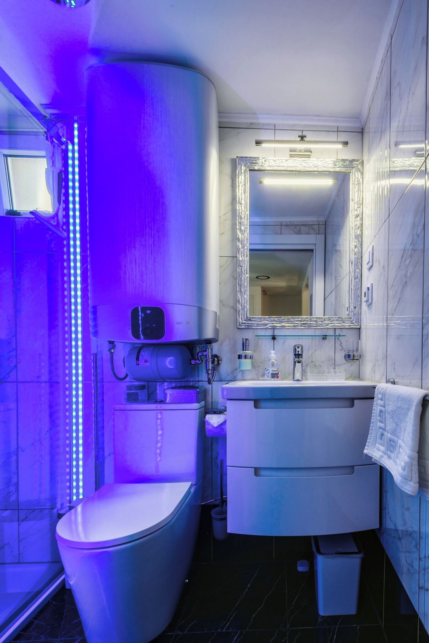Un baño moderno con inodoro, lavabo y espejo.